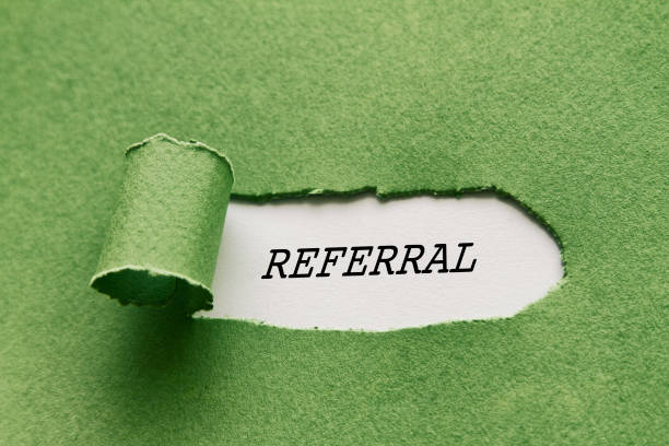 Torn green paper revealing the word REFERRAL